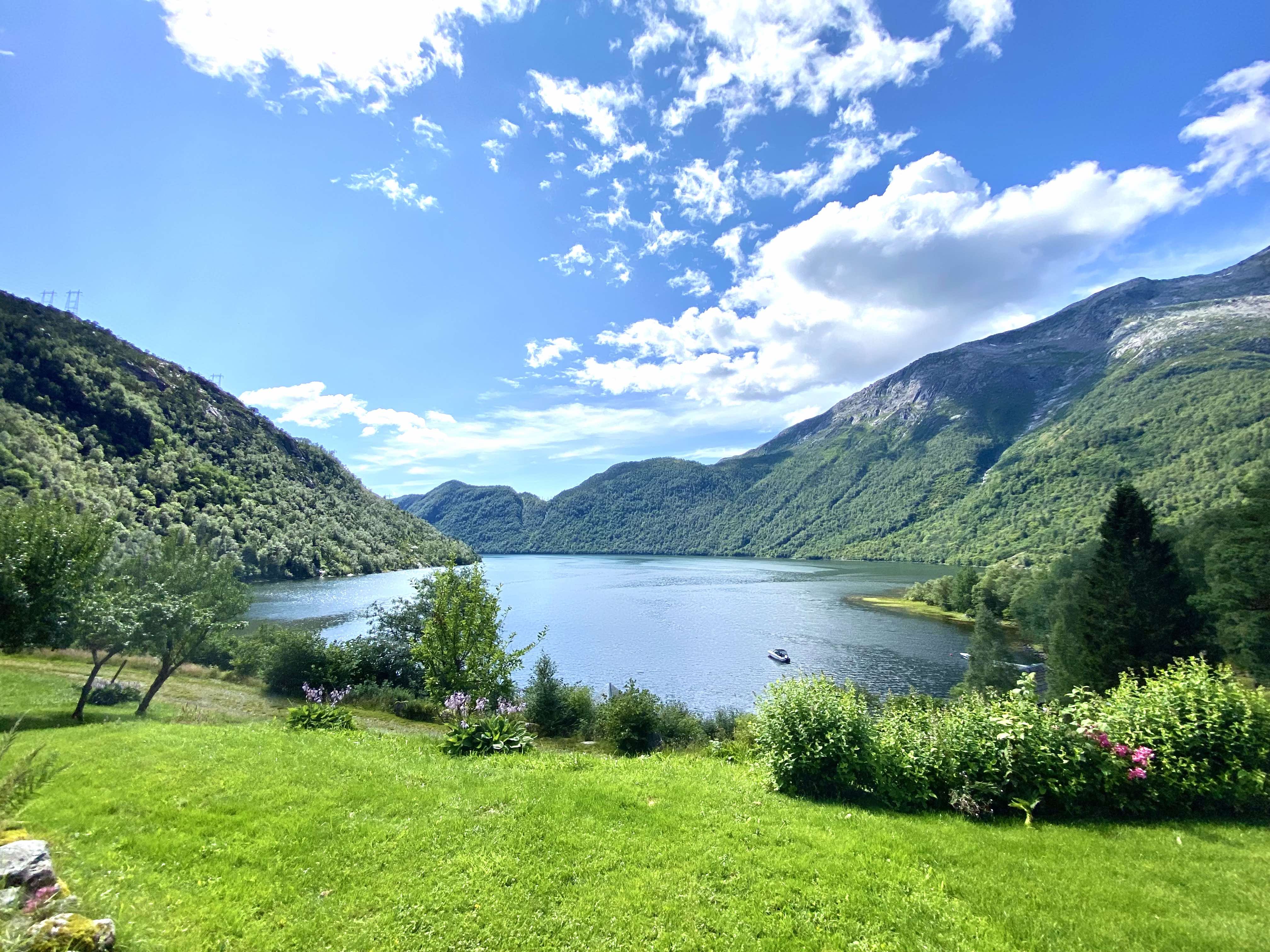 Utsikt over hav og fjell i solskinnsvær